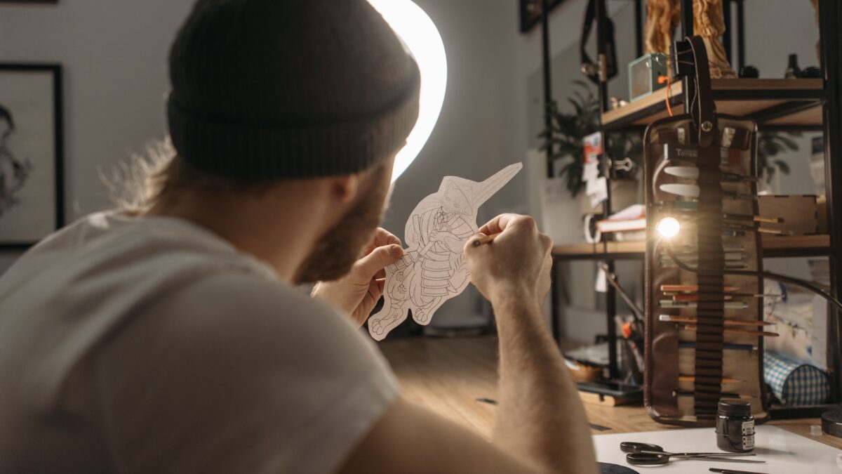 Tattoo artist reviewing a hand-drawn tattoo design in a studio